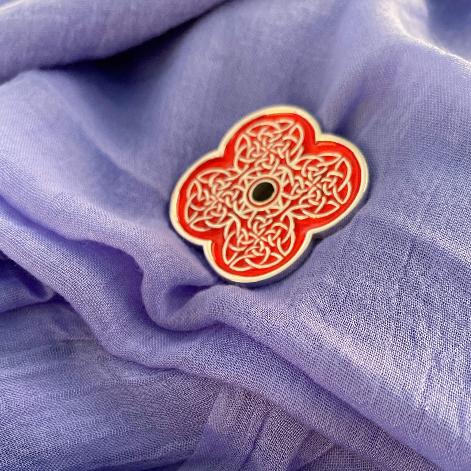 Woman with poppy brooch from the Poppyscotland jewellery Collection pinned to her scarf