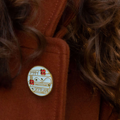 Mackintosh Style Poppy Brooch shown pinned on a woman's coat lapel - Poppyscotland